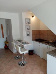 kuchnia z białymi szafkami, zlewem i stołem w obiekcie apartman Mirko w Puli +3 zdjęcia