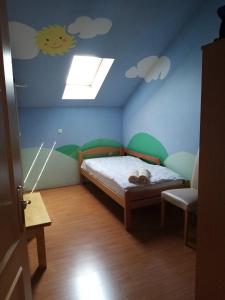 - une chambre pour enfants avec un lit et un plafond recouvert de nuages dans l'établissement Otok, à Mesihovina
