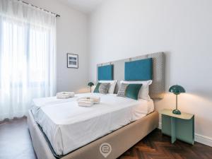 um quarto com uma cama grande e uma cabeceira azul em Verso Suite Cagliari - Charm in the City Centre em Cagliari