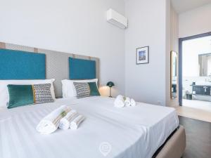 uma grande cama branca com três toalhas em Verso Suite Cagliari - Charm in the City Centre em Cagliari