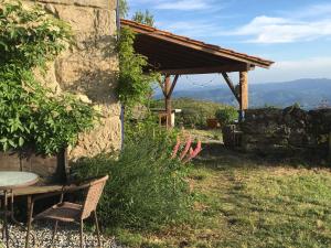 a table and a chair in front of a building at Mountain Log Cabin O Garrano in Cabeceiras de Basto