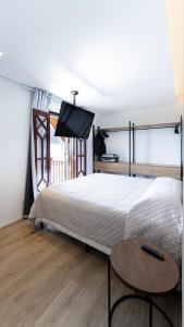 a bedroom with a large bed and a table at Apartamento Duplex de luxo em Campos do Jordão in Campos do Jordão