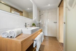 a bathroom with a white sink and a shower at Berghaus Mucha - Ferienwohnungen - Naturpark Partner in Bolsterlang +73 photos