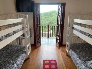 a room with two bunk beds and a balcony at Lindo Duplex em Campos do Jordão in Campos do Jordão