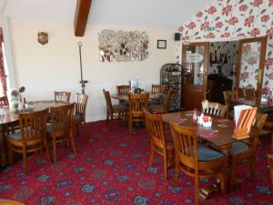 a dining room with wooden tables and chairs at Fox and Hounds Country Inn in Willingham