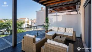 a balcony with chairs and tables on a building at Apartment Micaela in Vale do Lobo