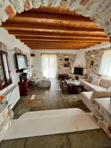 a large living room with a stone wall at Stone Villa Mina in Angairiá