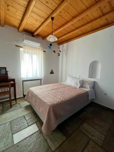 a bedroom with a bed and a wooden ceiling at Stone Villa Mina in Angairiá