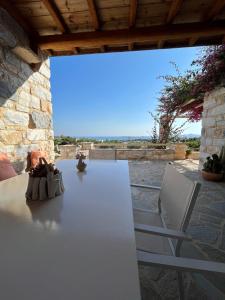 a white table and chairs on a patio at Stone Villa Mina in Angairiá