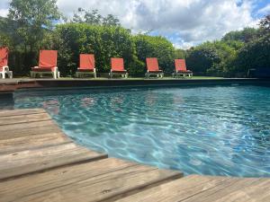 eine Reihe von Stühlen im Pool in der Unterkunft La Clavelière in Saint-Auban-sur-Ouvèze