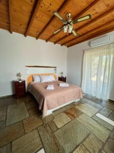 a bedroom with a bed and a ceiling fan at Stone Villa Mina in Angairiá