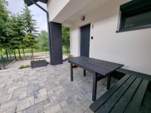 a patio with a wooden table and a bench at Apartament Na Kamieńcu w Dolinie Dunajca nr 1 in Tylmanowa