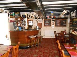 un restaurante con bar, mesas y sillas en Fox and Hounds Country Inn en Willingham