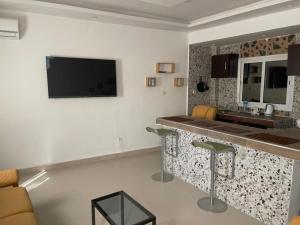 a kitchen with a counter and a tv on the wall at CAB LFS SIPRES MOURTADA 3e ETAGE in Dakar