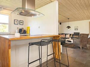 cocina con barra con taburetes en una habitación en 10 person holiday home in Bl vand, en Blåvand