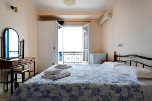 1 dormitorio con cama, escritorio y ventana en Stelios Hotel, en Spetses