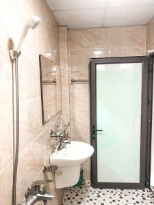 y baño con aseo, lavabo y ducha. en Khách sạn Lâm Viên, en Pho Mới