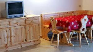 a kitchen with a table and chairs and a television at Agritur Al Paradis - Appartamenti in Portolo