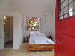 sypialnia z łóżkiem i czerwonymi drzwiami w obiekcie Fishermans House w mieście Khlóï