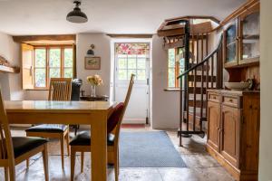 a kitchen and dining room with a table and chairs at Woodview - cosy 1840s cottage in Chew Valley and Mendip AONB in Compton Martin