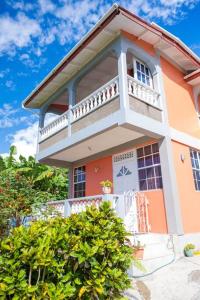 a orange and white house with a balcony at Perfect Family Home Close to Roseau in Roseau