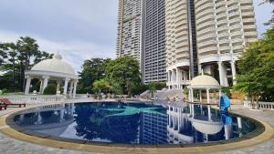 a large swimming pool in front of a tall building at Sky Beach Pattaya in North Pattaya