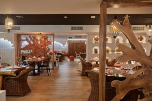 Sandos Benidorm Suites في بنيدورم: مطعم فيه طاولات وكراسي في الغرفة