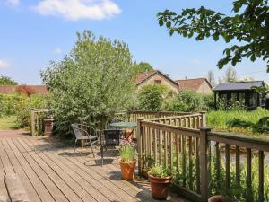 a wooden deck with a table and chairs on it at The Calf Pen in Colyton