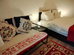 Cette chambre comprend deux lits et un canapé avec des oreillers. dans l'établissement Poiana Sașilor - Valea Doftanei, à Trăisteni