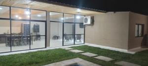 ein Haus mit Glasfenstern und einer Terrasse mit einem Tisch in der Unterkunft CASA TIPO CHALET SALTA in Salta