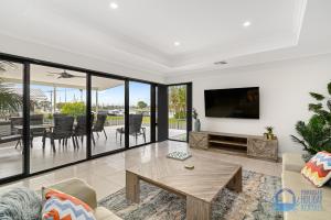 a living room with a tv and a table at Water Lovers Haven in Mandurah in Mandurah