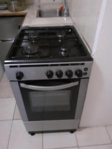 a stove in a kitchen with a sink at Cosy Corner in Saint Georgeʼs