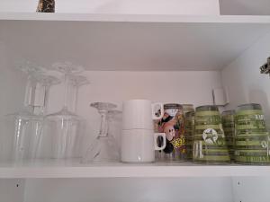 a shelf with cups and other glass items on it at Aries Apartment in Belgrade