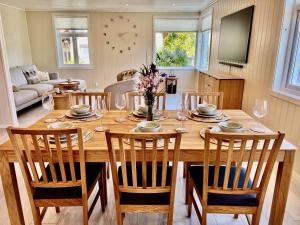 a wooden table with chairs and a dining room at Hardangerfjord View - luxury fjord-side holiday home in Øystese