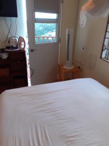 a bedroom with a white bed and a window at Cosy Corner in Saint Georgeʼs