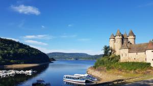 zamek na brzegu rzeki z łodziami w obiekcie Huttopia Lac de la Siauve w mieście Lanobre