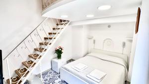 a white bedroom with a staircase and a bed at Residenza Giuseppe in Amalfi