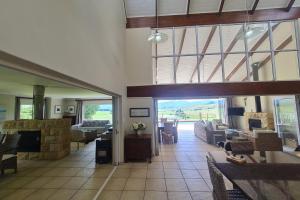 a living room with couches and a large glass door at 25 Hazyview Drakensburg Mountain Views in Underberg