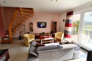 a living room with a couch and a staircase at Ferien_HAUS FOHLENWEIDE in Göhren-Lebbin