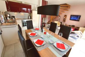 a kitchen with a dining table with red napkins on it at Ferien_HAUS FOHLENWEIDE in Göhren-Lebbin