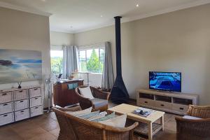 a living room with a tv and a table and chairs at 25 Hazyview Drakensburg Mountain Views in Underberg