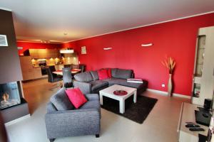 ein Wohnzimmer mit roten Wänden, einem Sofa und einem Tisch in der Unterkunft Ferienhaus CASA PRIMERA in Göhren-Lebbin