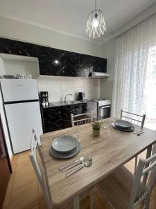 uma cozinha com uma mesa de madeira com placas em Eirini's House em Paralia Dionysiou