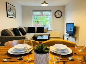 una sala de estar con una mesa con platos y copas de vino en Family Home in Residential Neighbourhood en Cardiff