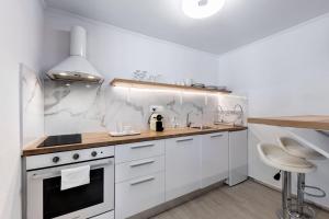 a white kitchen with a stove and a sink at Seaside Nestie by BluPine in Athens