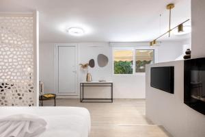 a white room with a bed and a television at Seaside Nestie by BluPine in Athens
