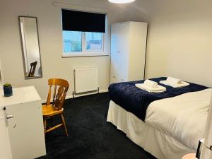 1 dormitorio con 1 cama, 1 silla y 1 ventana en Family Home in Residential Neighbourhood en Cardiff