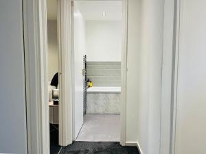 korytarzem prowadzącym do łazienki z wanną w obiekcie Family Home in Residential Neighbourhood w Cardiff