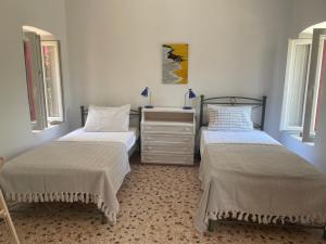 2 Betten in einem Zimmer mit 2 Fenstern in der Unterkunft Fishermans House in Khlóï