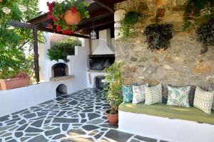 um pátio com almofadas num banco e uma parede de pedra em Ktima Dimitrios em Naxos Chora